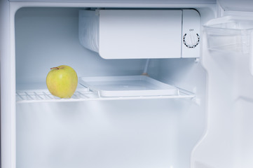 One apple in open empty refrigerator