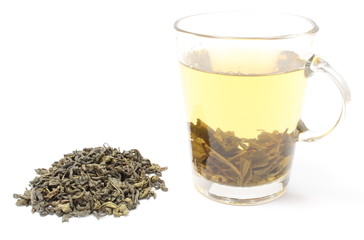 Heap of green tea and cup of beverage. White background