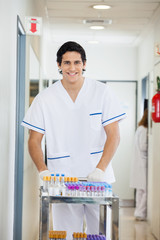 Obraz premium Technician Pushing Medical Cart In Hospital Hallway