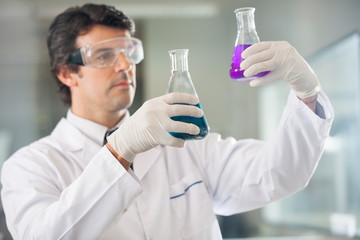 Fototapeta premium Scientist Examining Flasks With Different Samples
