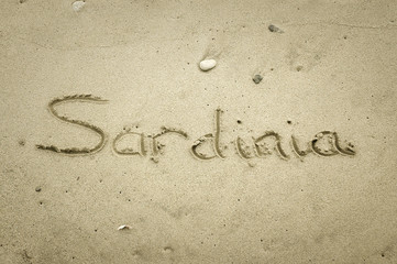 Sardinia - written in sand on beach texture