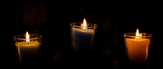 Burning candle on black background.