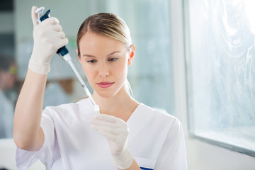 Scientist Filling Liquid Into Test Tube In Medical Lab