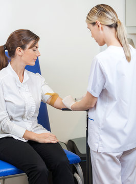 Nurse Drawing Blood From Businesswoman's Arm