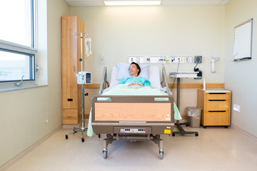 Patient Lying On Bed While Looking At Window In Hospital