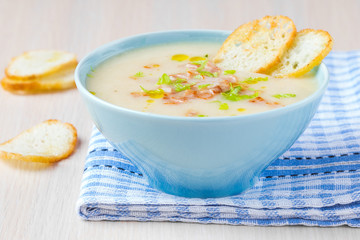 Delicious vegetable cream soup with potatoes, celery, ham, fresh