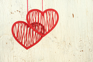 Two paper hearts on a  old  white wood