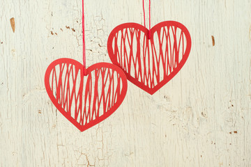 Two  red   paper hearts on a  old  white wood
