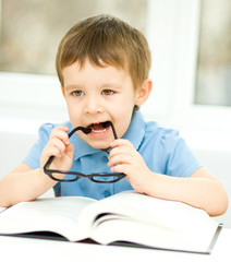 Little boy is reading a book