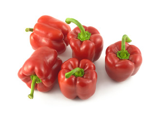 Five whole red ripe bell peppers isolated close up