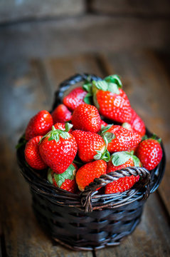Basket of fresh strawberries on wooden background
