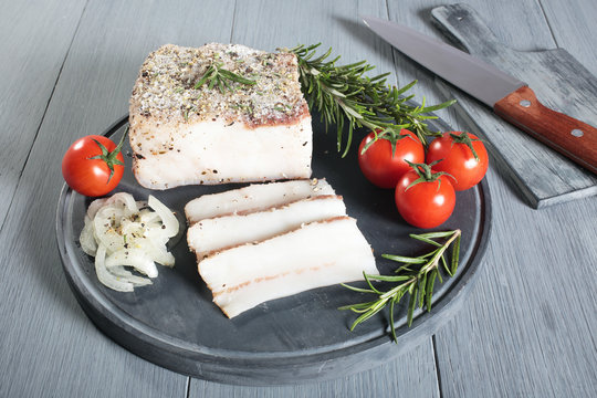 lardo salato con spezie sfondo grigio