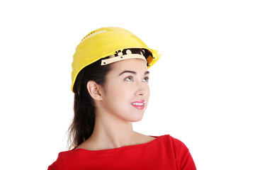 Female worker in helmet looking up.