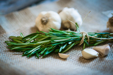 Fresh rosemary with fresh garlic on wooden background © ehaurylik