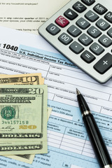 Fototapeta premium Tax form with pen, calculator, and dollar banknote taxation conc