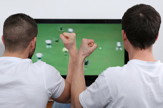 Junge Leute schauen Fu&szlig;ball im Fernsehen