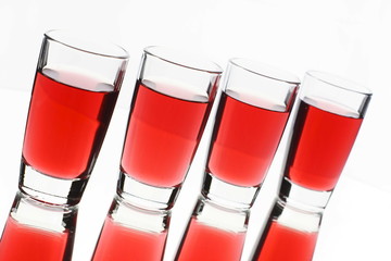 Several red alcohol shots on white background