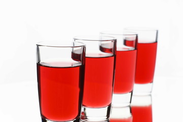 Several red alcohol shots on white background