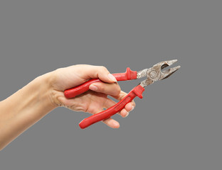 pliers in hand on gray background