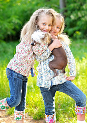 Portrait of two little girls twins with a dog