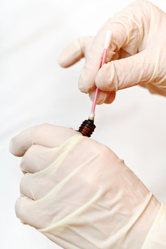 Nurse Dips Cotton Swab Into Bottle With Iodine