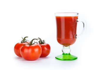 red tomatoes and glass of tomato juice on a white background