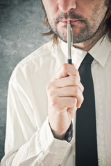 Businessman thinking with pencil in his mouth