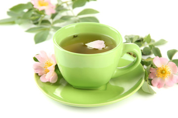 Cup of herbal tea with hip rose flowers, isolated on white