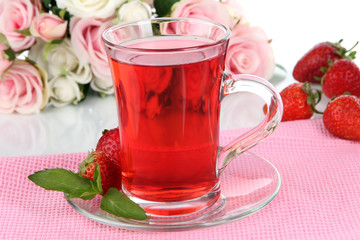 Delicious strawberry tea on table on white background