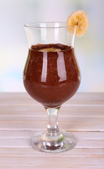 Cocktail with banana and chocolate on table on light background