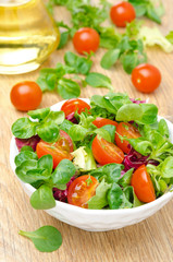 bowl of fresh salad and cherry tomatoes in white bowl, vertical