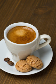 cup of coffee and biscotti on a wooden table