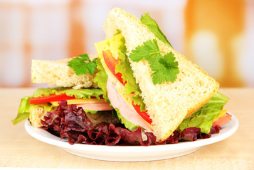Fresh and tasty sandwiches on plate on table on light