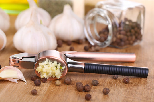 Composition with garlic press, fresh garlic and glass jars with
