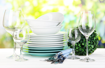 Clean dishes on table on natural background
