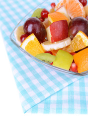 Sweet fresh fruits in bowl on table close-up