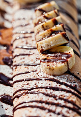 crepe with bananas and ice cream on white plate
