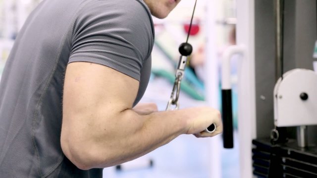 man at the gym, training triceps hands with