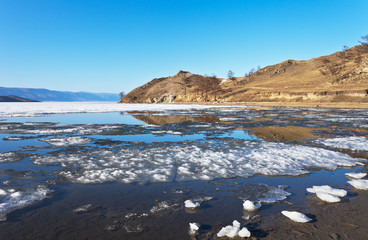 Sunny day at Baikal Lake. Spring floating of ice
