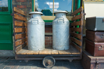 Milk churns on wooden trolley