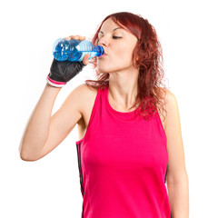 Young sport girl drinking water over white background