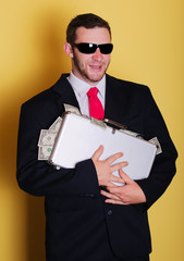 Business man hold suitcase with full of money notes