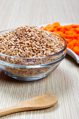 dried spelt and carrots in a bowl on a table