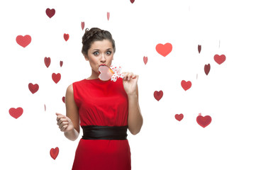 caucasian woman in red dress licking lollipop