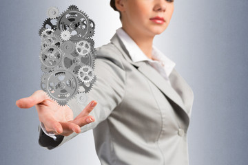 business woman holds up a mechanism of gears