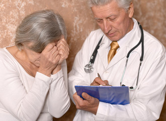 Obraz premium Sad senior woman with doctor