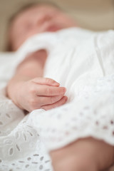 Defocused hand detail of a sleeping newborn baby girl