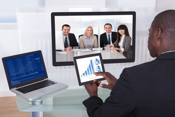 Businessman In Conference Analyzing Graph