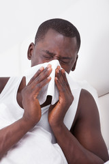 Man Blowing His Nose In A Handkerchief