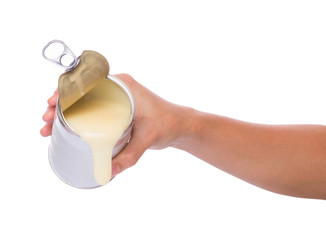 Female hand pouring condensed milk over white background